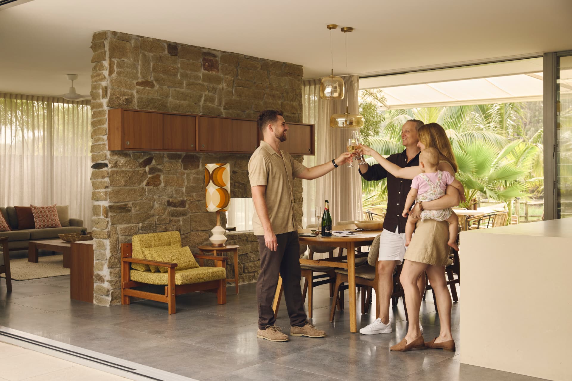 A family toasting with their buyer's agent in the living room of their new home
